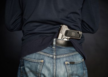 Hided handgun under the denim belt.
