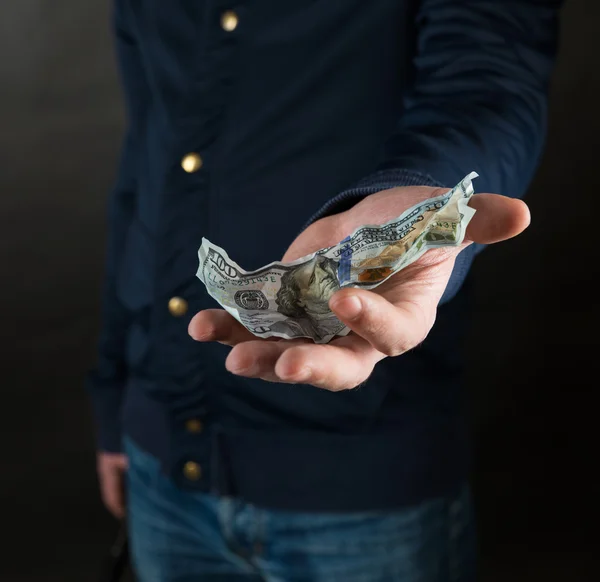 Feche a mão do macho que está segurando uma nota de dólar. . — Fotografia de Stock