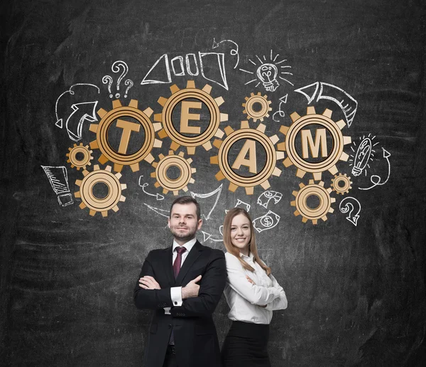 Pareja de negocios están pensando en la cooperación en un proyecto empresarial. Engranajes dibujados en la pared con el equipo de palabra. El concepto del trabajo en equipo . —  Fotos de Stock