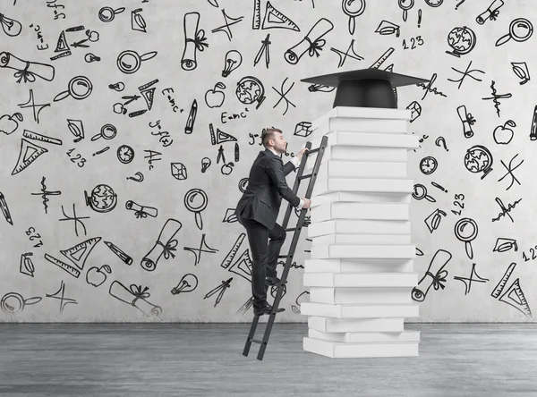 Ein Student klettert nach oben, um einen Universitätsabschluss zu erwerben. Stapel Bücher und ein Abschlusszeugnis als Preis. Konkreter Hintergrund mit Bildungsikonen. — Stockfoto