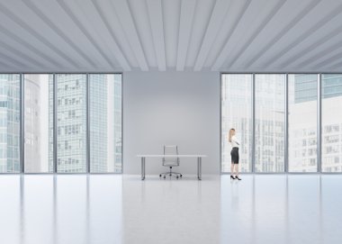 New York'ın panoramik ofisindeki pencereden dışarı bakan sarışın çalışan yan görünüm. Modern iş yeri kavramı.