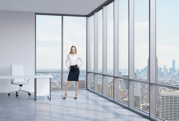 Bella dipendente sorridente è in piedi in ufficio con vista panoramica di New York. Un concetto del luogo di lavoro moderno . — Foto Stock