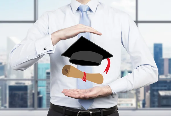A student placing his hands around the graduation attributes. New York background. — Stock Photo, Image