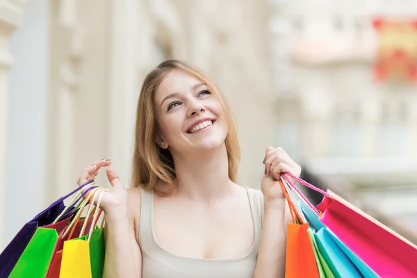 Ein fröhliches junges Mädchen mit den bunten Einkaufstüten aus den schicken Geschäften. — Stockfoto