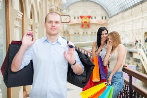 Leende flickor och en man med påsar i en lyxig central butik. Shopping, försäljning, gåvor och semester begrepp. Hög-street shopping. — Stockfoto