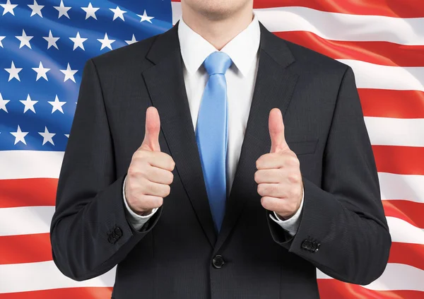 スーツの人は親指を立てます。背景として米国旗. — ストック写真