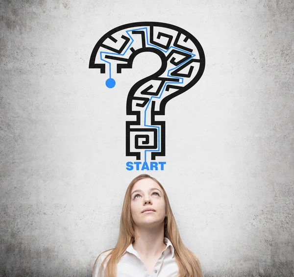 Beautiful woman is looking for the way how to solve the maze in a form of the question mark — Stock Photo, Image