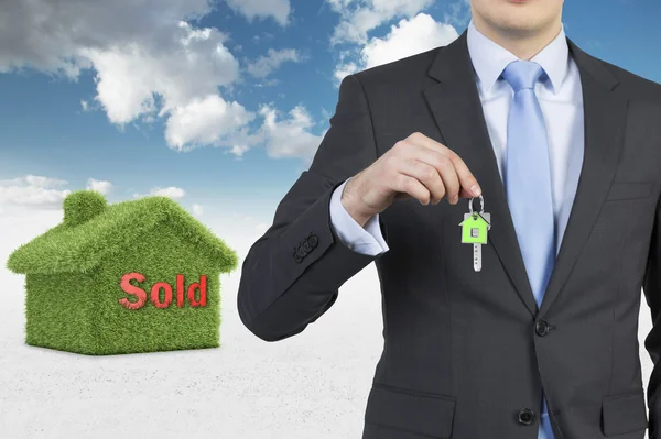 Confident real property agent is offering a key from a recently sold family house. — Stock Photo, Image