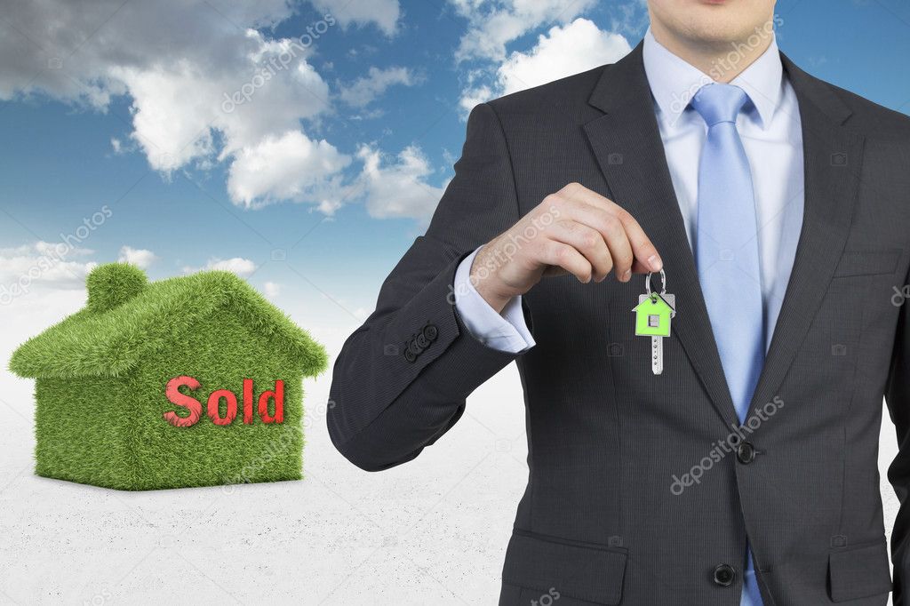Confident real property agent is offering a key from a recently sold family house.