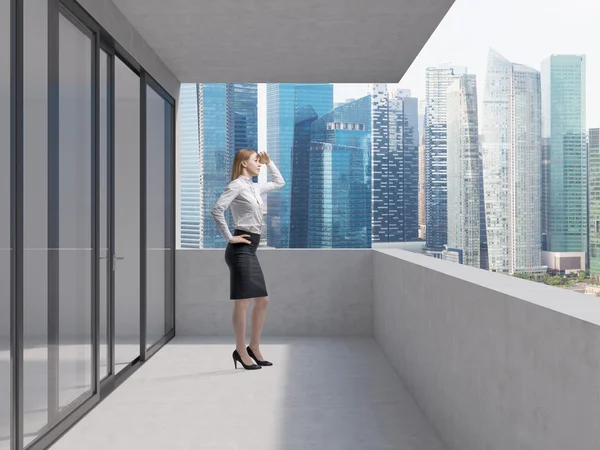 Young business lady is standing on the balcony of the skyscraper and looking at the new business perspectives. Singapore panoramic view. — Stock fotografie