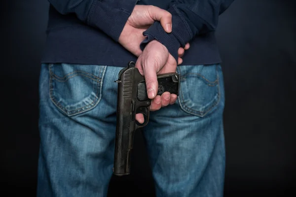 Närbild på bakifrån på den person som innehar en hand pistol. — Stockfoto