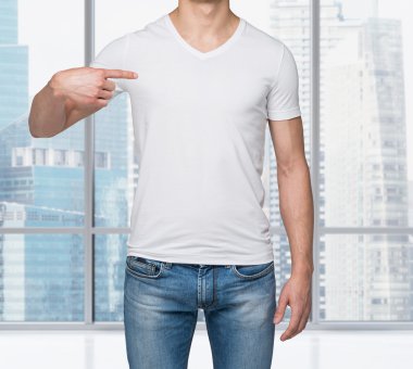 boş bir t-shirt üzerine onun parmak işaret eden birinin yakın çekim. New york modern bir ofis panoramik görünümü.