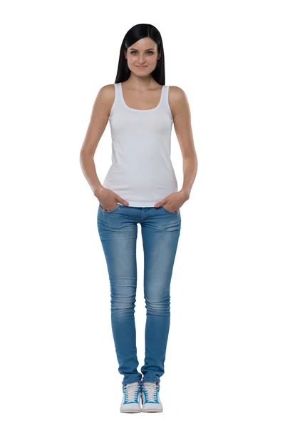 Full length of a brunette woman in a white tank top and jeans. Isolated. — Stock Photo, Image