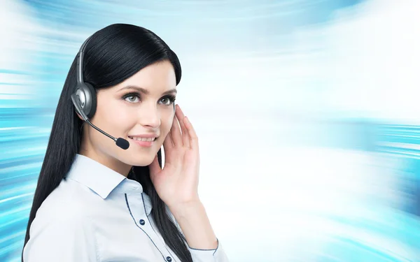 Portrait of smiling cheerful support phone operator in headset. Modern blue background. — ストック写真