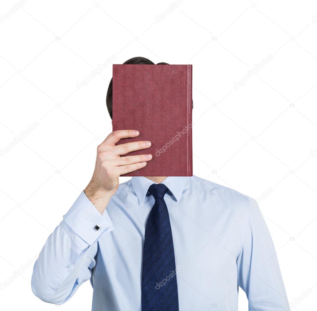 A person holds a red book in front of the head. Isolated.