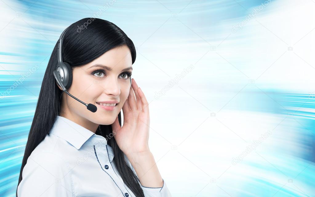 Portrait of smiling cheerful support phone operator in headset. Modern blue background.