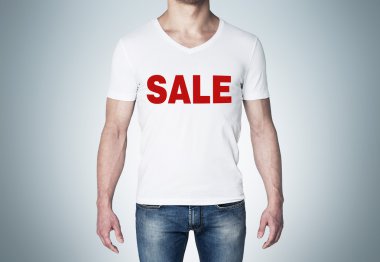 Close up of the body view of the man in a white t-shirt with the red word ' sale ' on the chest. Blue background.