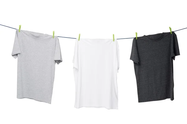 Close up of three t-shirts on the rope (grey, white and dark grey). Isolated. — Stock Fotó
