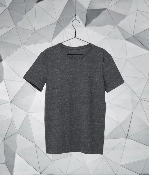 Primo piano di una t-shirt grigia su appendiabiti di stoffa. Sfondo moderno . — Foto Stock