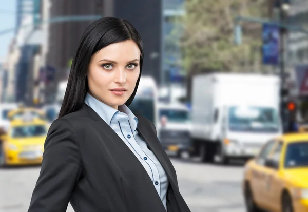 Portrait of a beautiful brunette lady in a formal suit. New York street background. — Stockfoto