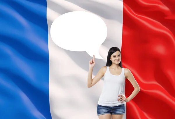 Beautiful woman is pointing out the empty thought bubble. French flag as a background. — Φωτογραφία Αρχείου