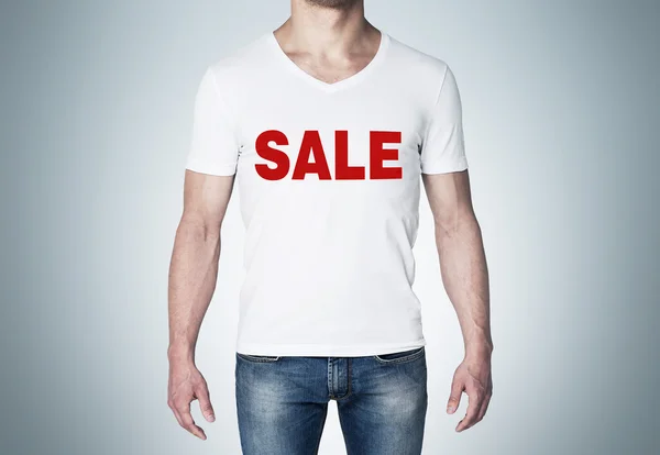 Primer plano de la vista corporal del hombre en una camiseta blanca con la palabra roja "venta" en el pecho. Fondo azul . — Foto de Stock