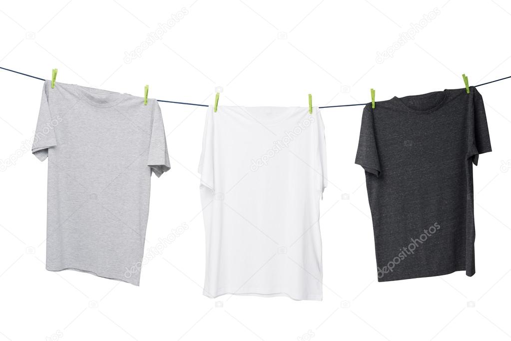 Close up of three t-shirts on the rope (grey, white and dark grey). Isolated.