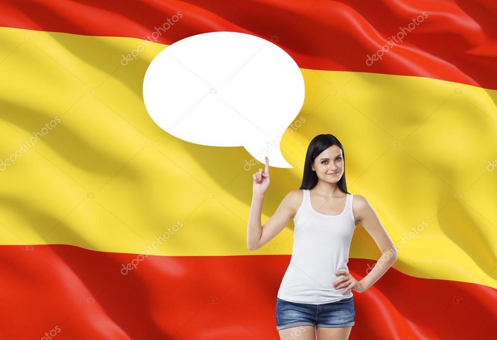 Beautiful woman is pointing out the empty thought bubble. Spanish flag as a background.