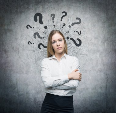 A portrait of a beautiful lady with questioning expression and question marks above her head. Concrete background.