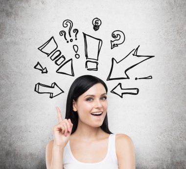 A portrait of an astonished brunette lady in a white tank top. Drawn arrows and questions marks around her head. Concrete background.