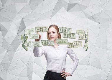 Young lady is controlling cash flow of the dollar notes. Contemporary background.