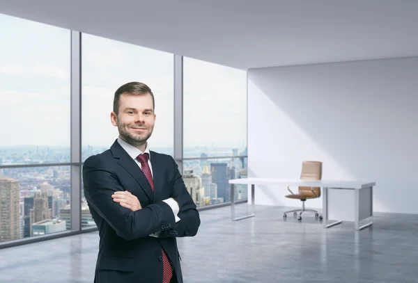 Ein gutaussehender unternehmer an einem arbeitsplatz im modernen panoramabüro an der ecke in new york, manhattan. ein Konzept der Finanzberatung. — Stockfoto