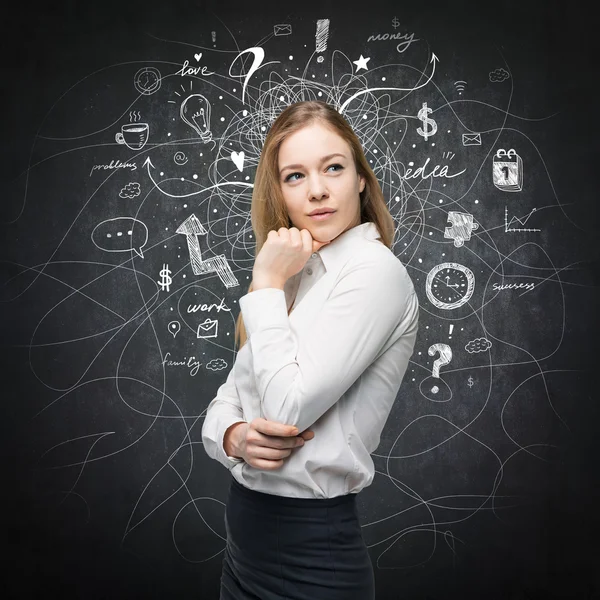 A portrait of a beautiful lady with questioning expression who is looking the best solution for the business problem. Chalk Business icons are drawn over the black chalkboard. — Stockfoto