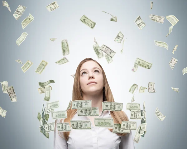 Young lady is looking upward. Dollar notes a falling down from the sky. — Stockfoto