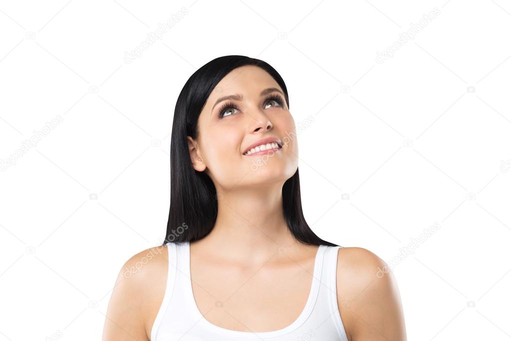 A Portrait of a dreamy brunette lady in a white tank top. Isolated.