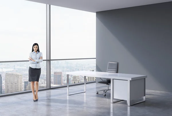 Una donna d'affari bruna in un posto di lavoro in un moderno ufficio panoramico a New York, Manhattan. Un concetto di servizi di consulenza finanziaria . — Foto Stock
