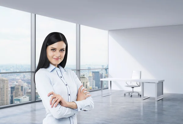 Una donna d'affari bruna in un posto di lavoro in un angolo moderno ufficio panoramico a New York, Manhattan. Un concetto di servizi di consulenza finanziaria . — Foto Stock