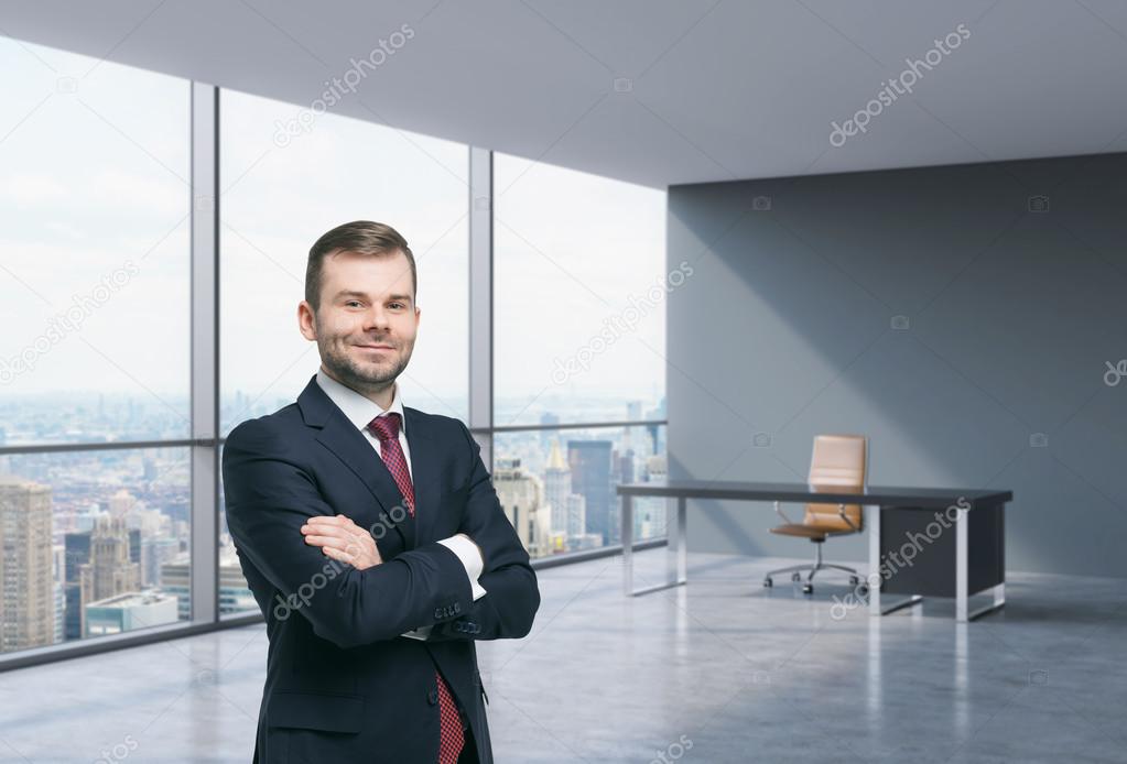 A handsome businessman in a workplace at modern corner panoramic office in New York, Manhattan. A concept of financial consulting services.