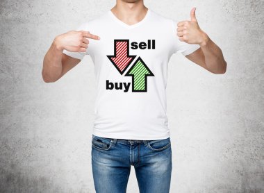 Close up of the man in denims and a white t-shirt pointing out to the chest with drawn arrows: buy and sell. The concept of the capital market and investor's behaviour. Concrete background.