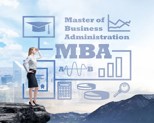 Businessman standing on a rock and looking at the future perspectives of MBA degree. Mountain landscape.