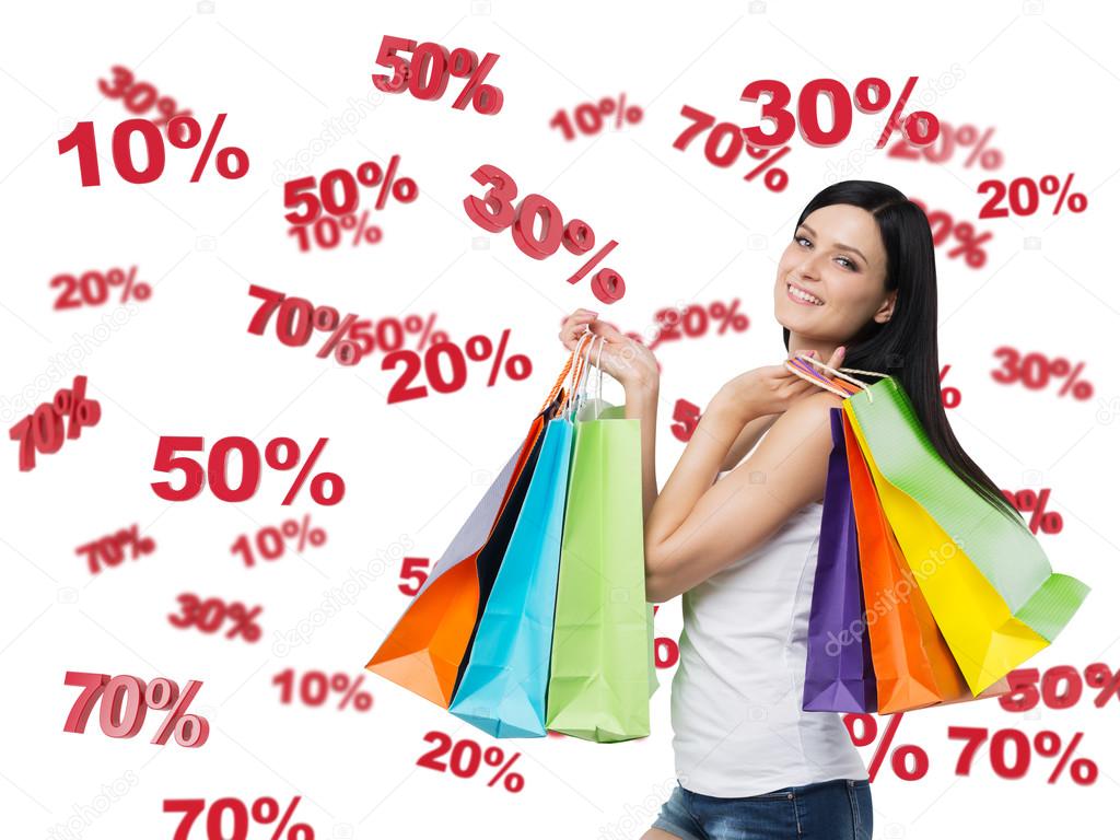 Happy brunette with the colourful bags. Discount and sale symbols: 10% 20% 30% 50% 70%. Isolated.