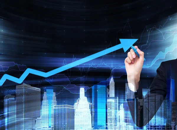 Bir el büyüyen bir ok cam ekranda çiziyor. Mali iş Hizmetleri kavramı. Cityscape hologramıdır.