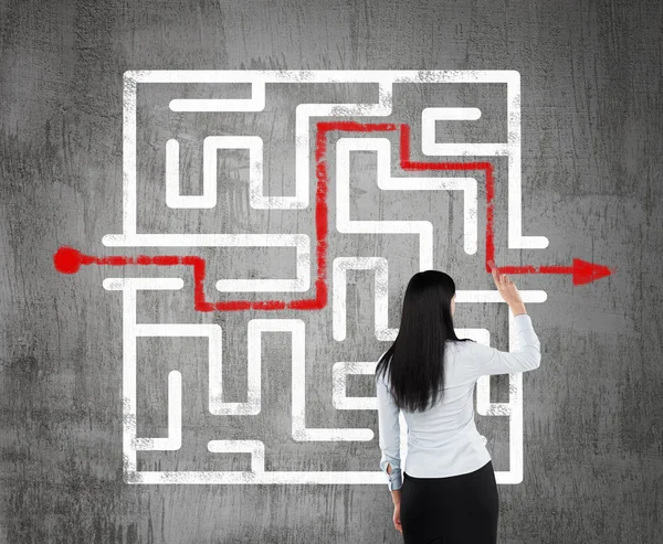 Brunette business woman finding the solution of a maze. — Stock Photo, Image