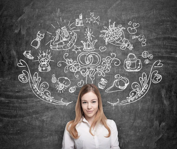 Young woman is dreaming about shopping. Shopping icons are drawn on the black chalkboard. — Stock Photo, Image