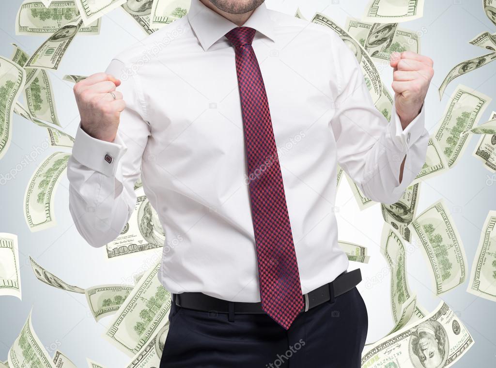 Closeup portrait of happy successful student, business man who has reached the goal. Fists pumped. The concept of celebrating the success. Dollar note are falling down over the isolated background.