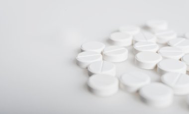 Spilled white pills on the white surface