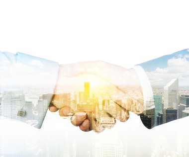 A transparent silhouette of a business handshake. New York cityscape on the background.