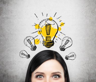 A head of young brunette lady who is thinking about new business ideas. A light bulb are drawn on the concrete wall.