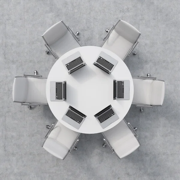 Вид зверху на конференц-зал. Білий круглий стіл, шість стільців. На столі стоять шість ноутбуків. Офісний інтер'єр. 3D візуалізація . — стокове фото