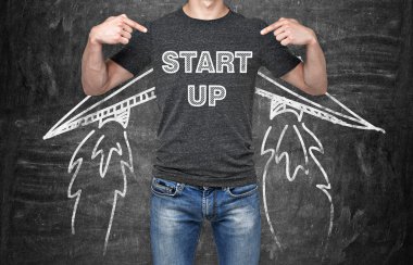 Bir iş adamı nerede kelime sıralama 'start up' göğüs işaret ediyor. Yeni işe başlayan bir kavram. Çizilmiş kanatları. Arka plan siyah Tebeşir tahtaya.
